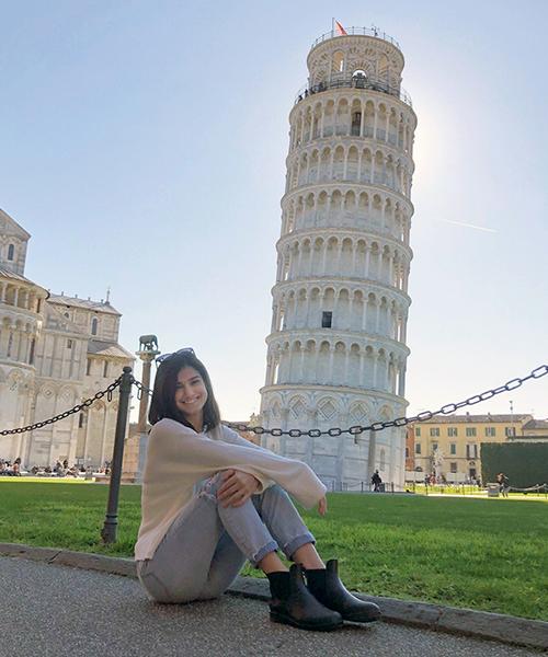 SBU student sitting with the leaning Tower of Pisa in the background
